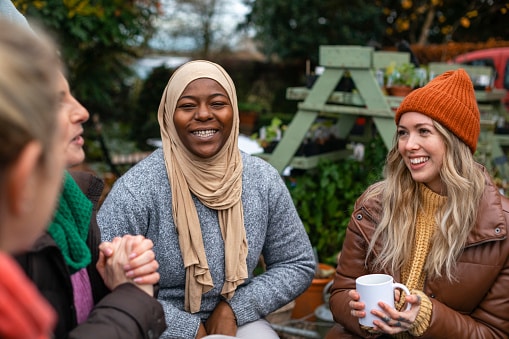 Group of people together talking and drinking warm drinks